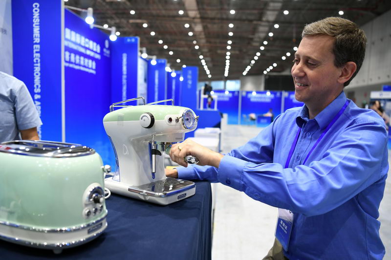 July 26, 2018: An exhibitor showcases a coffeemaker at a matchmaking meeting for exhibitors and buyers for the 2018 China International Import Expo.  by Jin Liangkuai/Xinhua